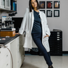 Woman in a lab jacket modeling The Rosalind™ Pants 2.0