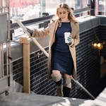 Woman walking holding a coffee wearing the Alice™ Antimicrobial Gloves